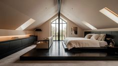 an attic bedroom with slanted ceilings and large bed