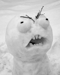 a snowman with its mouth open and eyes wide open, standing in the snow