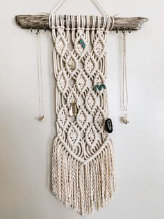 a macrame hanging on a wall with beads and other items attached to it