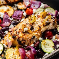 chicken and vegetables in a baking pan with feta cheese on top, ready to be eaten