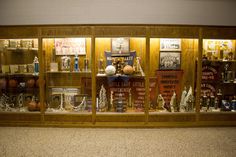 a display case filled with lots of trophies and trophy cups on top of wooden shelves