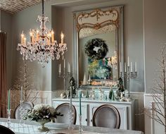 an elegant dining room with chandelier and table set for four people, decorated in white