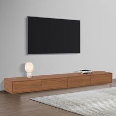 a flat screen tv mounted to the side of a wooden entertainment center in a living room