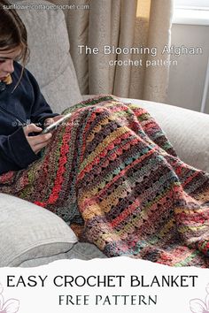 a woman sitting on a couch with a crochet blanket