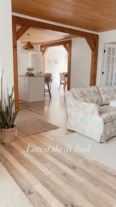 a living room filled with furniture next to a kitchen