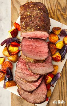 sliced roast beef and vegetables on a cutting board