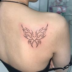 the back of a woman's shoulder with a butterfly tattoo on her left side