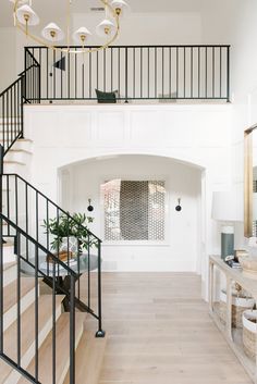 an instagram photo of a staircase in a house with white walls and black railings