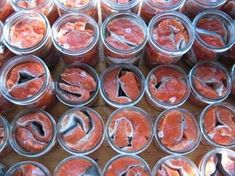 several glass jars filled with different types of meats and veggies in them