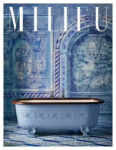 a bath tub sitting on top of a tiled floor next to a blue and white wall