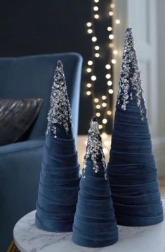 two blue christmas trees sitting on top of a table