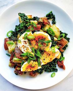 a white plate topped with eggs and greens