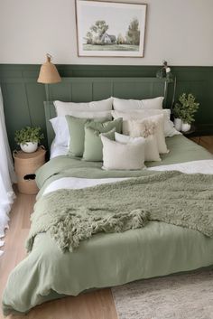 a bed with green sheets and pillows in a room