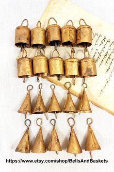 an old book with bells hanging from it's sides next to some other items