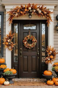 a front door decorated for fall with pumpkins and gourds