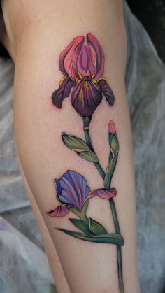 a close up of a person's leg with a flower tattoo on it,