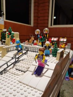 a table with legos on it and some people in the background, all made out of white bricks