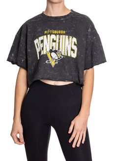 Woman standing in front of a white background wearing an oversized, black, acid wash crop top - featuring a Pittsburgh Penguins logo in the center of the shirt. Acid Wash Relaxed Fit Cropped Tops, Acid Wash Cropped Top Relaxed Fit, Sporty Black Washed Top, Acid Wash Casual Cropped T-shirt For Spring, Casual Acid Wash Cropped T-shirt For Spring, Acid Wash Cropped T-shirt For Spring, Acid Wash Cropped Cotton Tops, Sporty Acid Wash Distressed Top, Distressed Cotton Crew Neck Crop Top