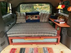 the interior of a camper van with bed and pillows