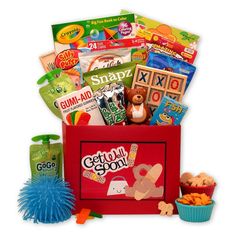 a red box filled with lots of toys and snacks on top of a white surface