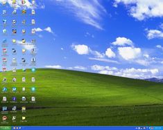 the windows xp wallpaper is green and has blue skies above it with white clouds