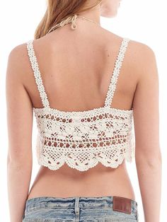 the back of a woman's top that is crocheted with white lace