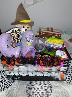 a basket filled with purple clogs and items on top of a white bed