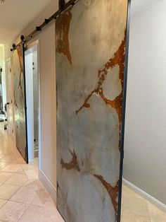 a hallway with marble walls and flooring next to an open door that leads to another room