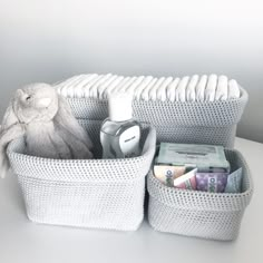 a stuffed animal sitting in a white basket filled with personal care items and toiletries