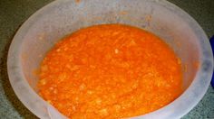 a white bowl filled with carrots on top of a counter next to a blue container