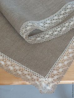 two pieces of linen with lace on them sitting on a table top next to each other