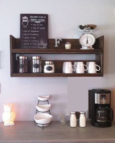 there is a coffee bar with cups on the shelf and an alarm clock above it