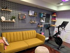 a yellow couch sitting next to a bike in a room