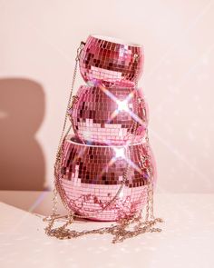 three pink disco ball purses stacked on top of each other with chains hanging from them