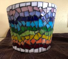 a multicolored glass vase sitting on top of a table