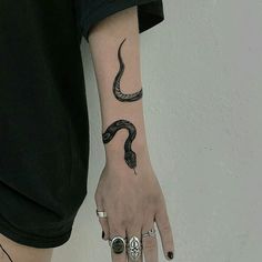 a woman's arm with a snake tattoo on it