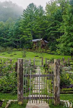 an open gate leading into a lush green yard