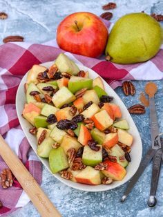 a bowl filled with apples and pecans on top of a table