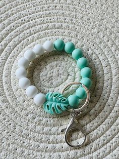 This listing is for the white and mint green Beaded Silicone wristlet keychain! You will have the choice of a silver or gold keychain clasp. The perfect gift for anyone. Hang keys or an ID badge for easy accessibility Wristlets are stretchy. Please easily roll onto your wrist.  Pull tested for durability. Keep out of reach from children White Beaded Keychains For Everyday Use, White Round Beads Keychains For Everyday Use, White Bohemian Beaded Bracelets With Lobster Clasp, White Bohemian Bracelet With Lobster Clasp, Trendy White Beaded Wristlet, White Round Beads Bracelets For Everyday Use, Everyday White Round Bead Bracelets, Trendy White Bracelets With Lobster Clasp, White Adjustable Wristlet With Key Leash