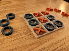 an ice tray with pieces of orange and black plastic on top of a wooden table