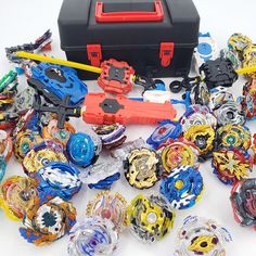 a bunch of different types of toys on a white surface with a tool box in the background