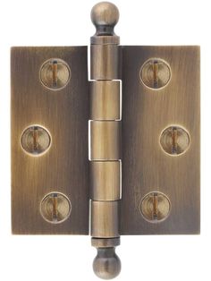 an antique brass finish door hinge with four knobs and two holes on each side