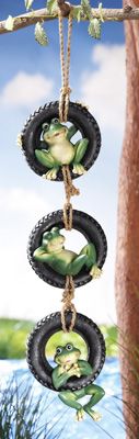 a frog hanging from a tree branch with tire tires on it's sides and two green frogs in the middle