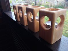 three wooden vases sitting on top of a window sill