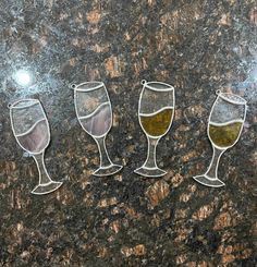 three wine glasses sitting on top of a counter