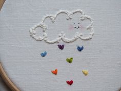 an embroidered cloud with hearts on it