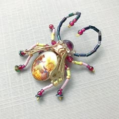 a colorful spider brooch sitting on top of a table