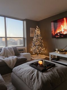 a living room filled with furniture and a christmas tree in front of a large window