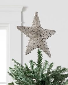 a christmas tree with a star decoration hanging from it