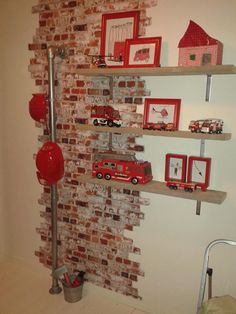 there is a red fire truck on the shelf next to some pictures and other items